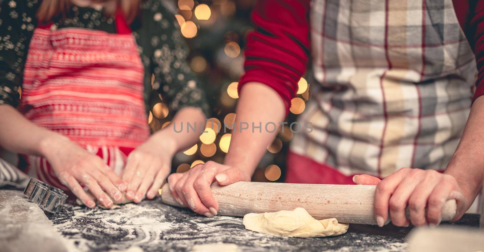 Preparing dough for gingerbread baking with rolling pin together at home