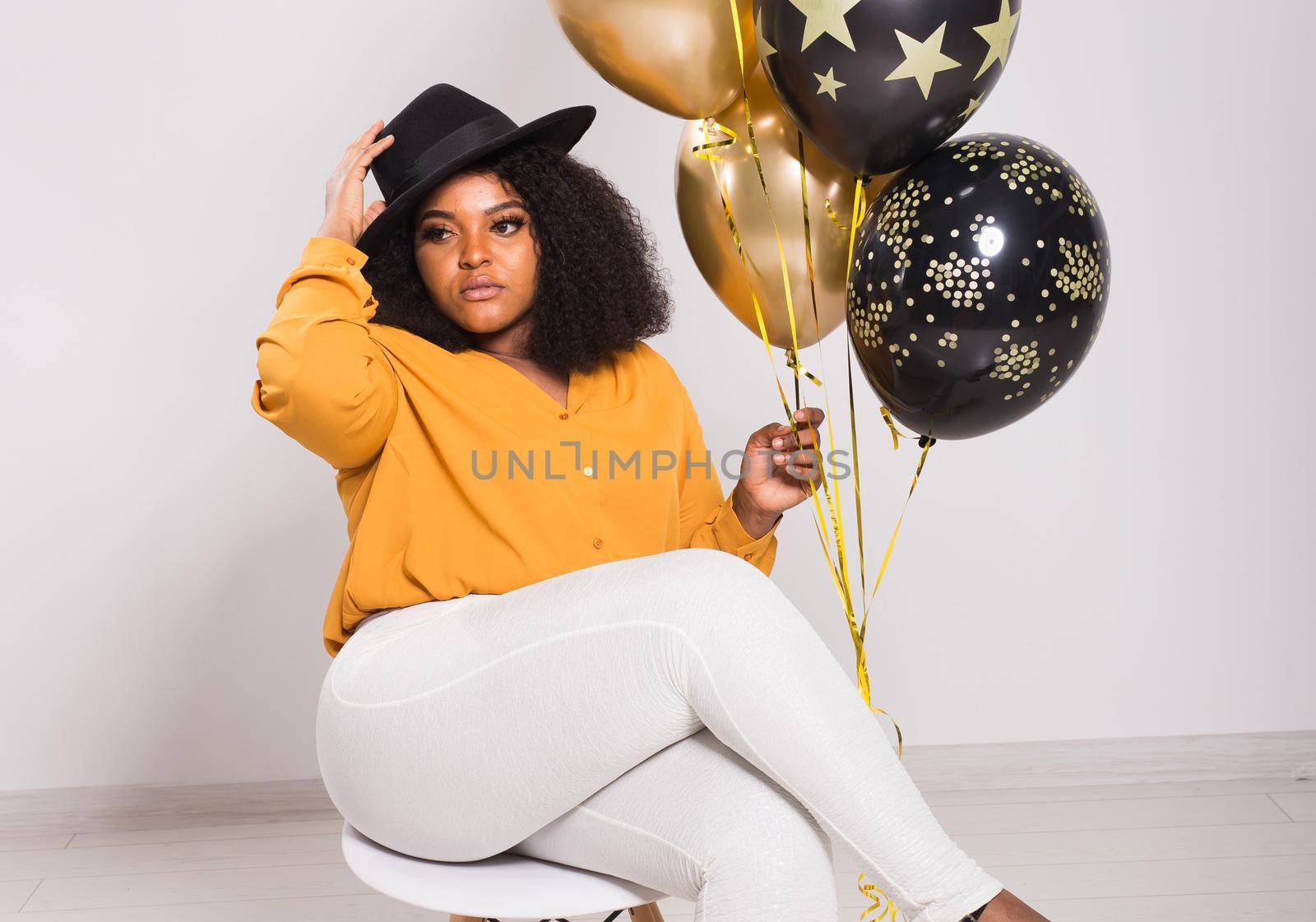 Holidays, birthday party and fun concept - Portrait of smiling young African-American young woman looking stylish on white background holding balloons. by Satura86