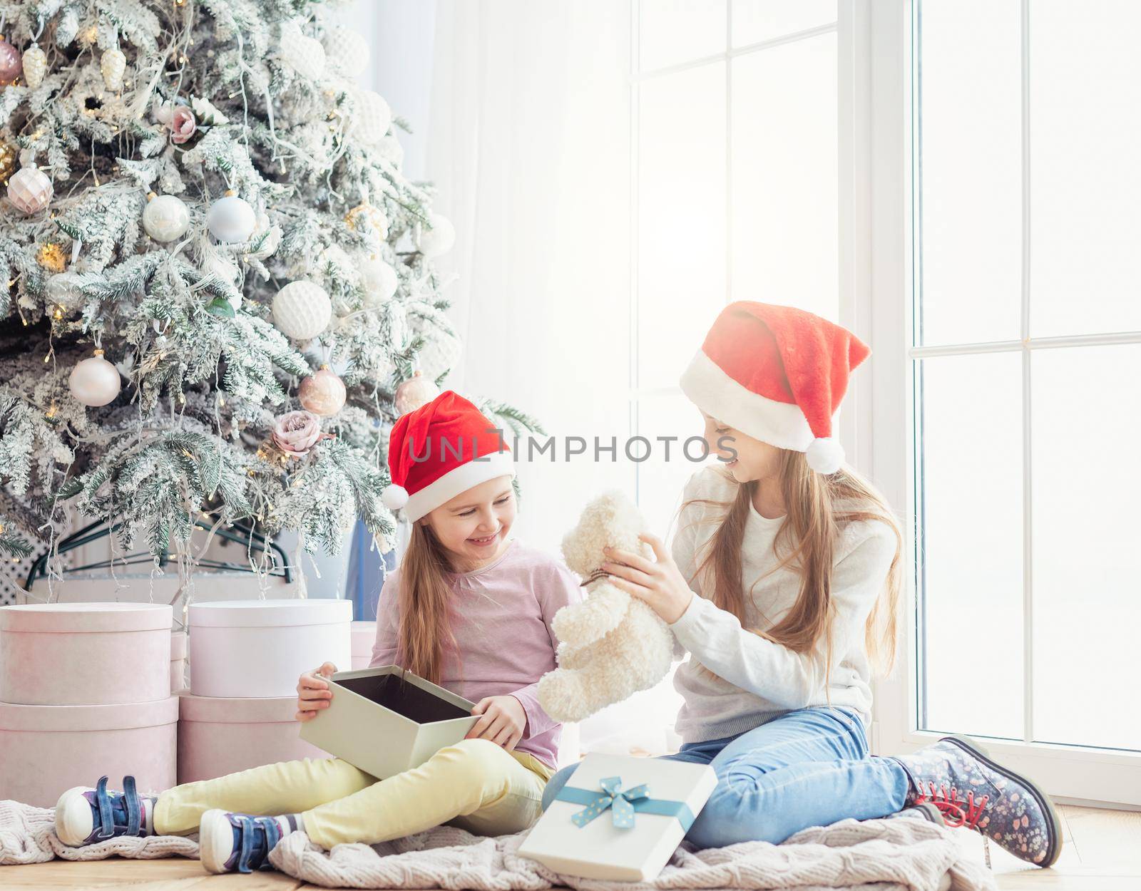 Smiling sisters taking opened gifts by tan4ikk1