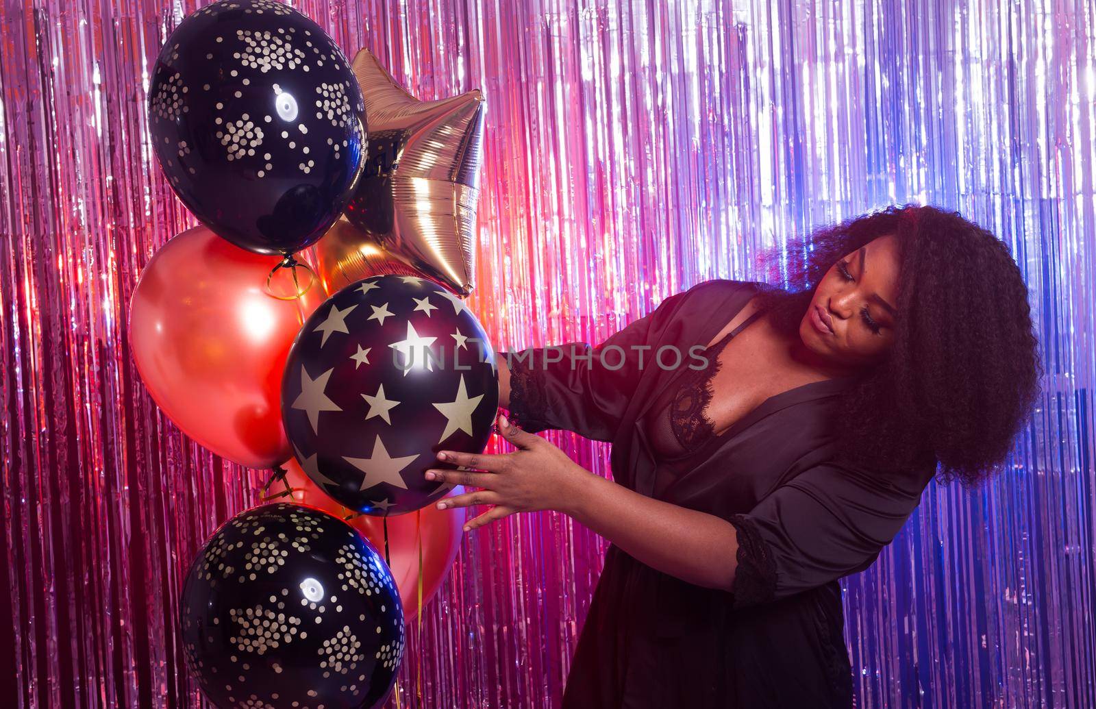 Portrait of a beautiful african american woman against twinkling background. Birthday party, nightclub and nightlife.