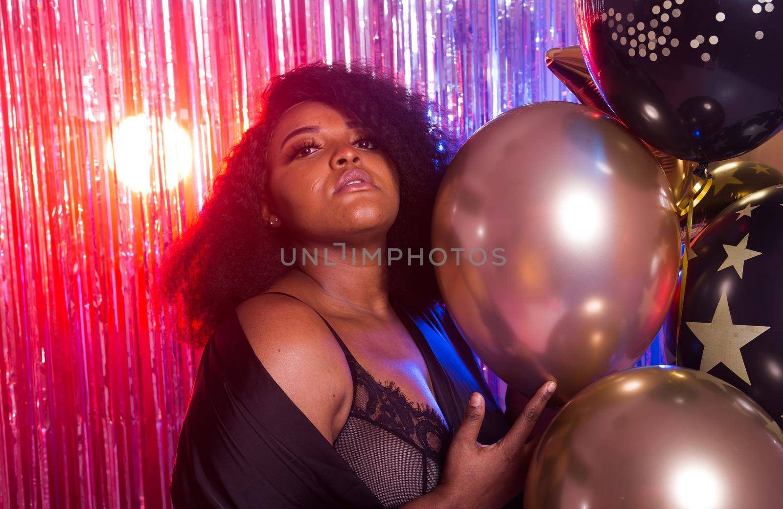 Portrait of a beautiful african american woman against twinkling background. Birthday party, nightclub and nightlife concept. by Satura86