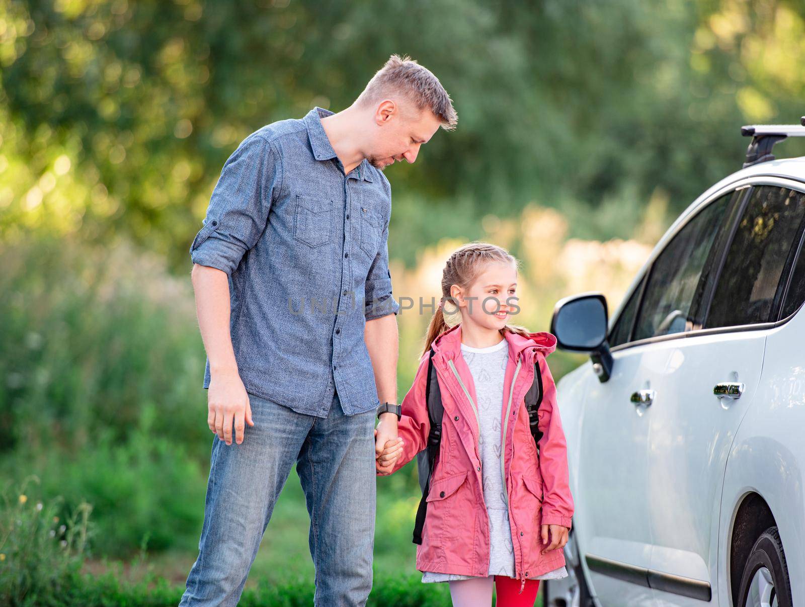 Little girl going back to school holding hands with father