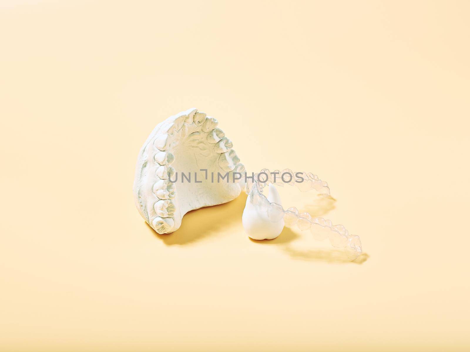 Orthodontic dental theme on  yellow background.Transparent invisible dental aligners or braces aplicable for an orthodontic dental treatment by Maximusnd