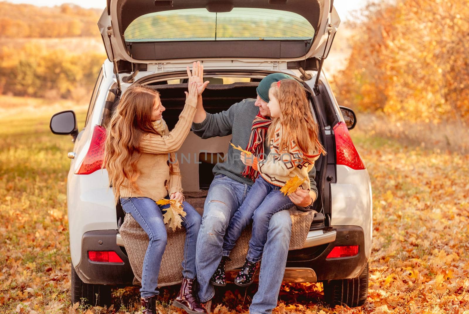 Smiling father with daughters in autumn surroundings