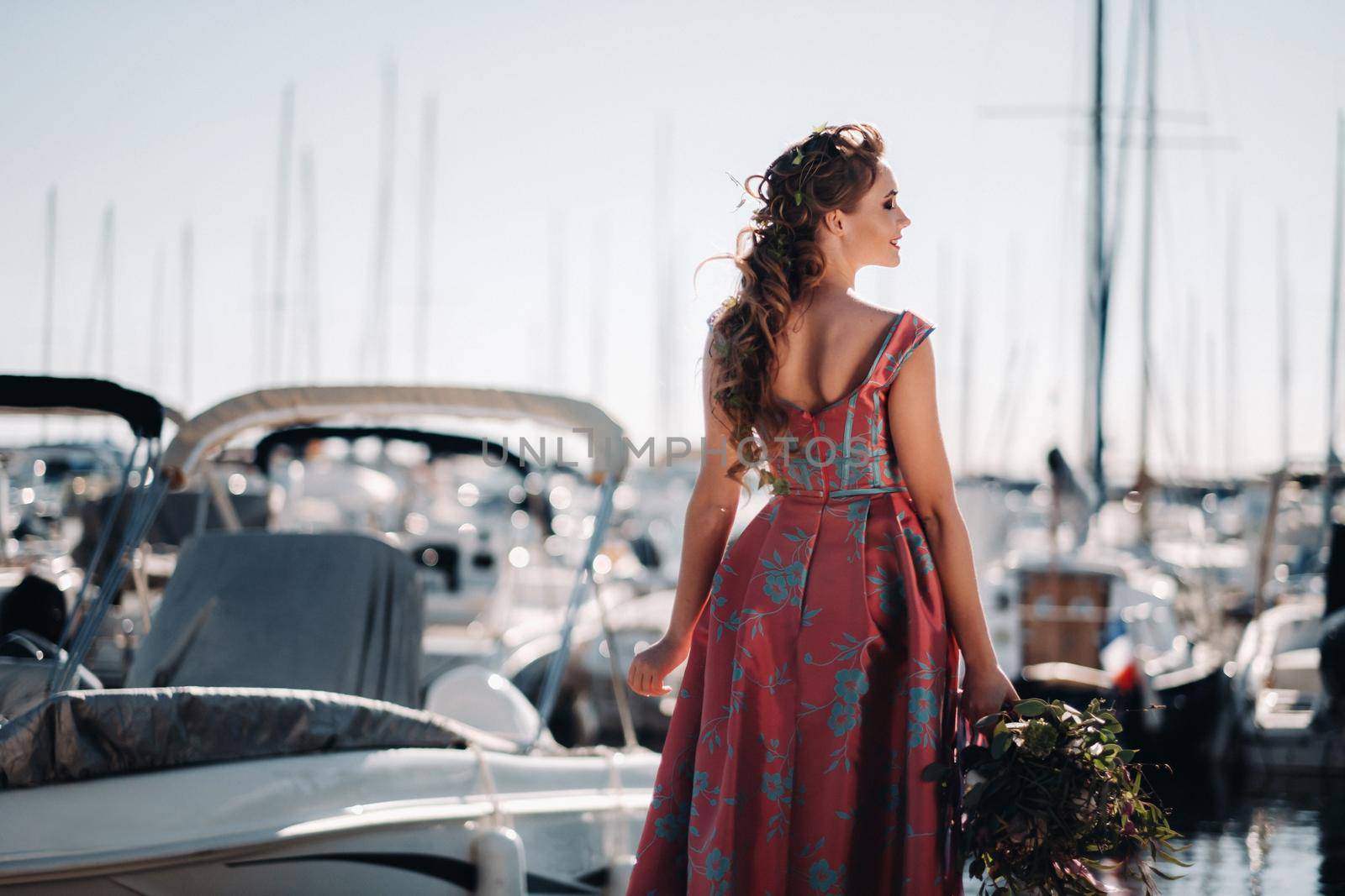 Young model girl in a beautiful dress with a bouquet of flowers on the beach in France. Girl with flowers in spring Provence on the French Riviera.