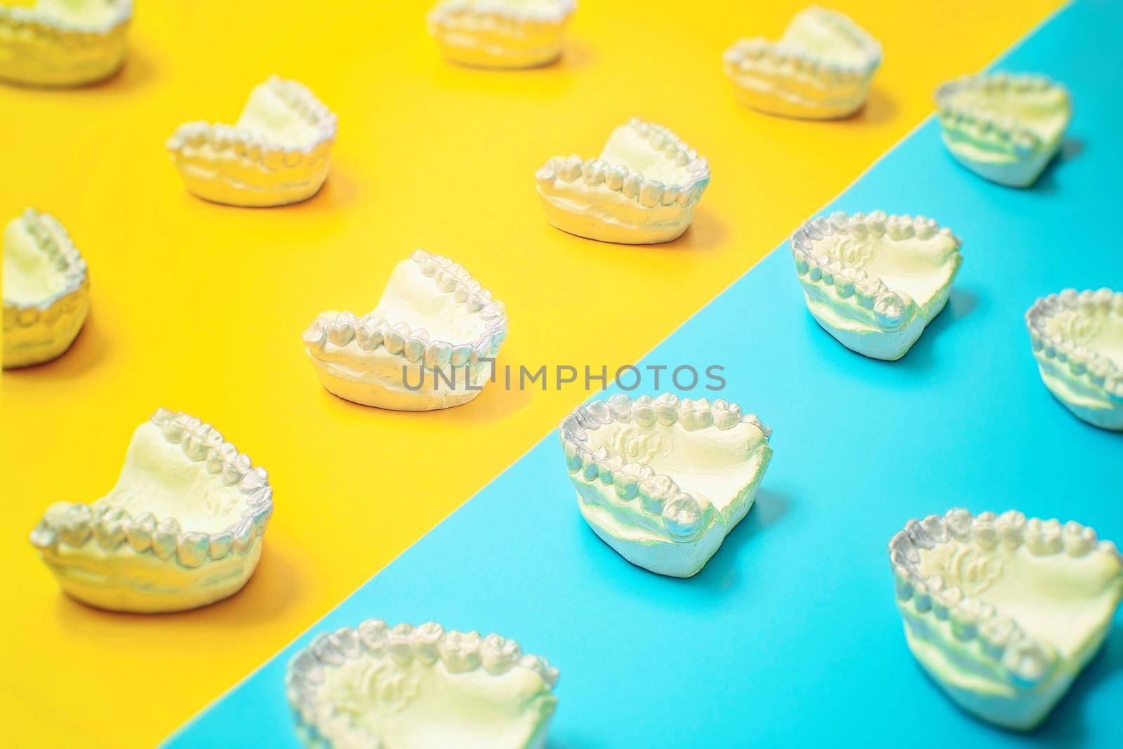 Orthodontic dental theme on blue and yellow background.Transparent invisible dental aligners or braces aplicable for an orthodontic dental treatment