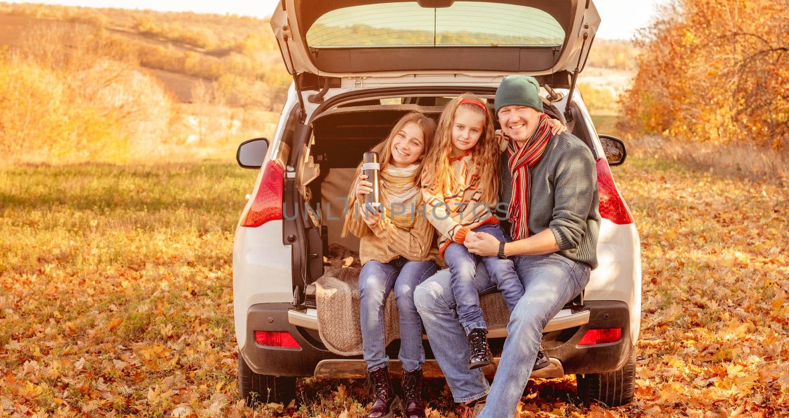 Smiling father with daughters in autumn surroundings