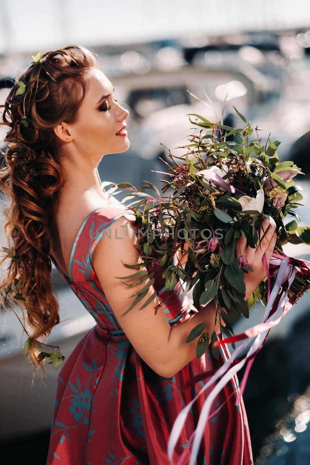 Young model girl in a beautiful dress with a bouquet of flowers on the beach in France. Girl with flowers in spring Provence on the French Riviera.