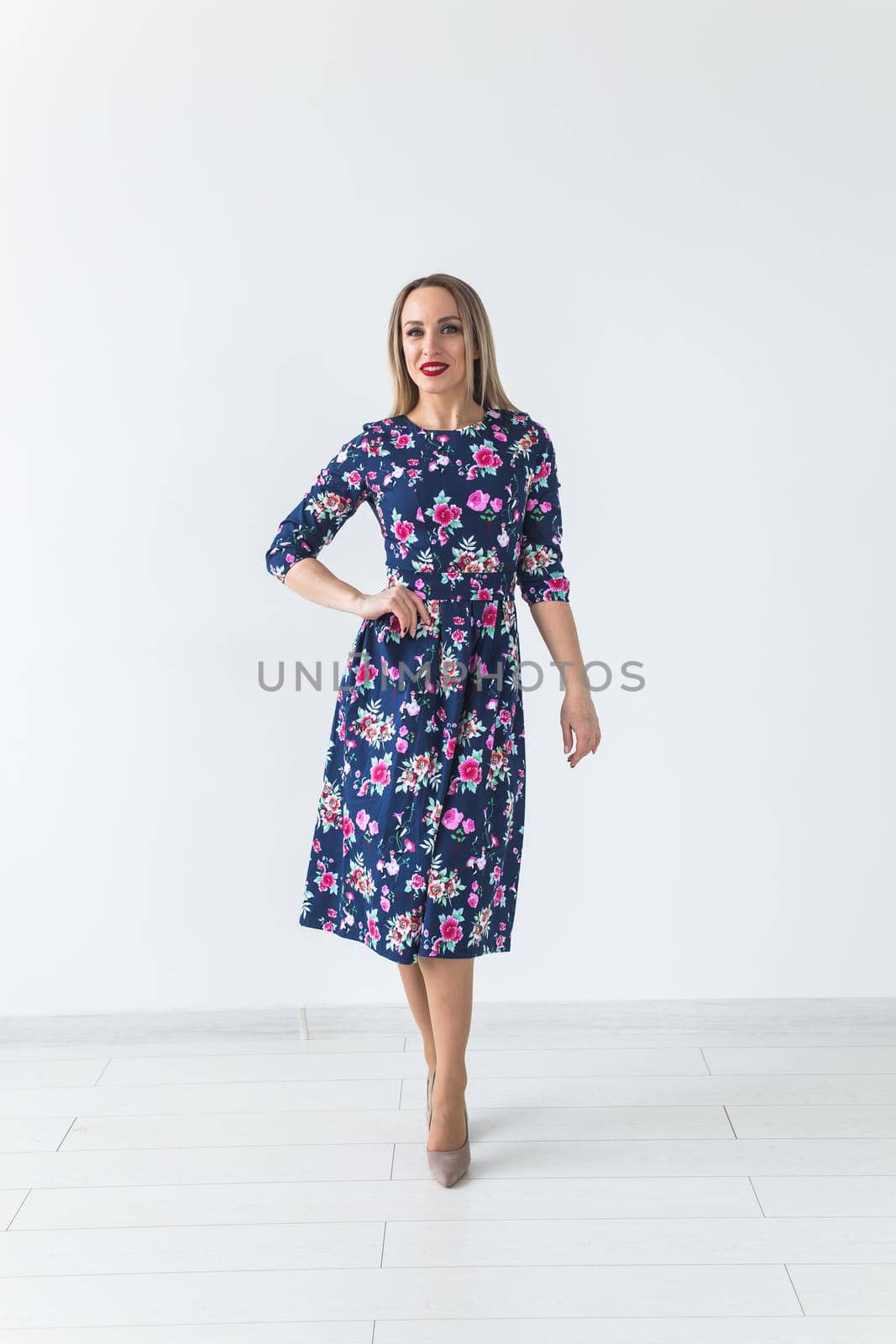 Fashionable young woman in beautiful dress posing at studio. Isolated over white.