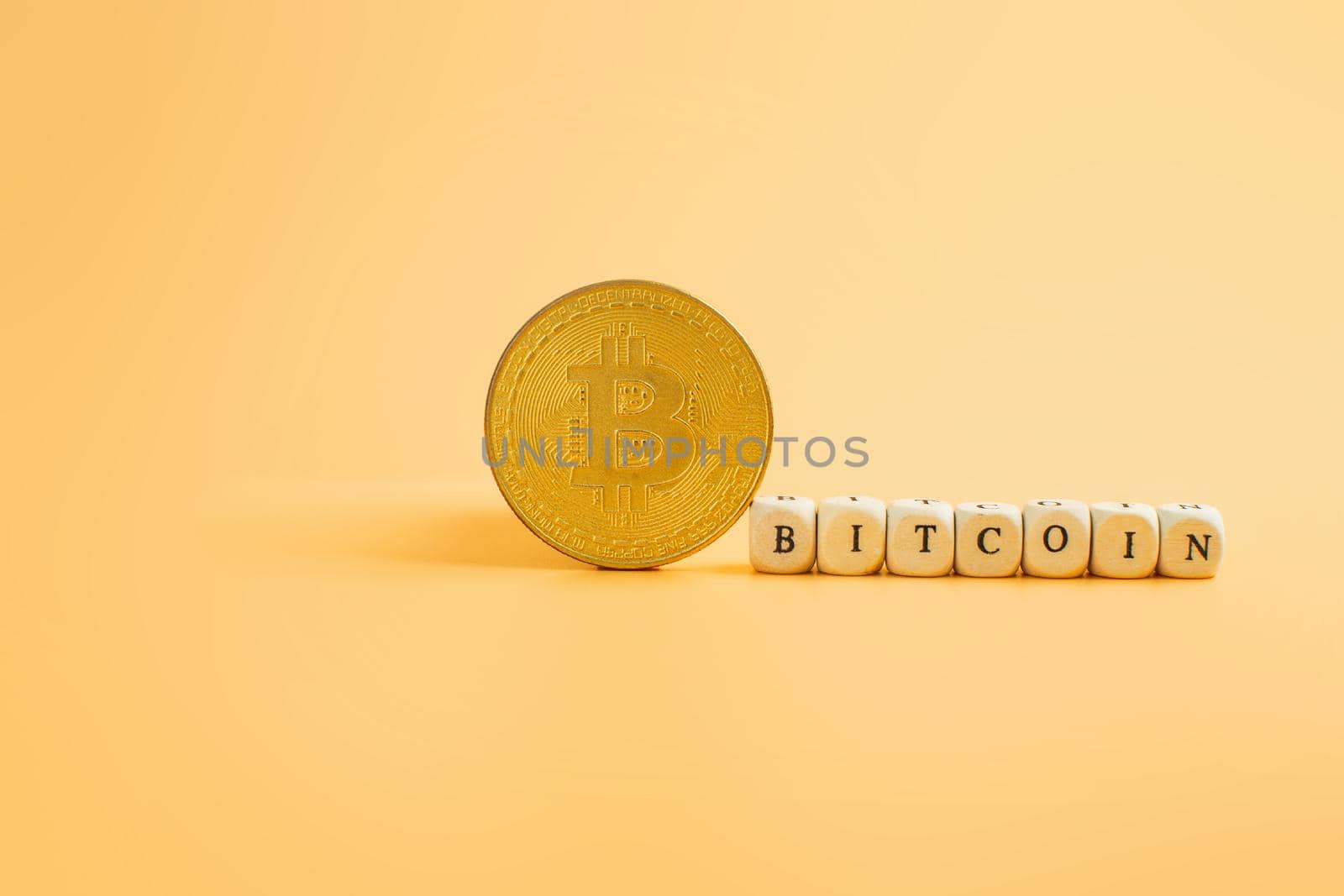 Bitcoin in a minimalist concept on a yellow background with the inscription Bitcoin