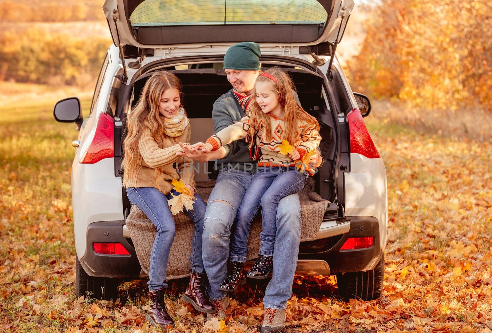 Smiling father with daughters in autumn surroundings