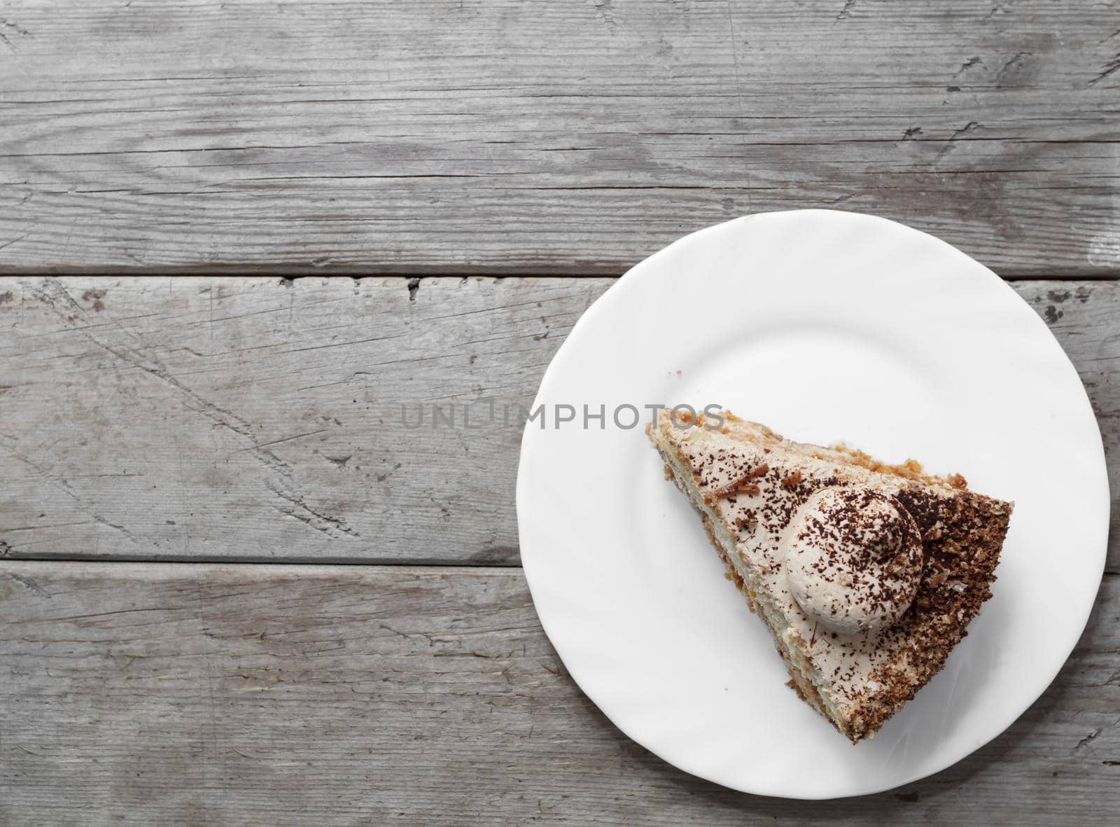 Piece of cake on the wooden table, top view, space for text