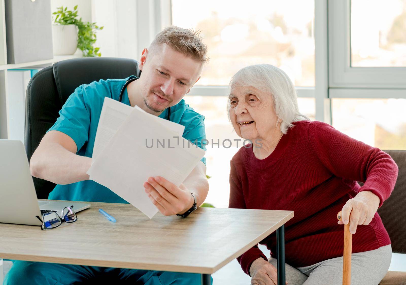 Physician explaining treatment to old lady during appointment in clinic