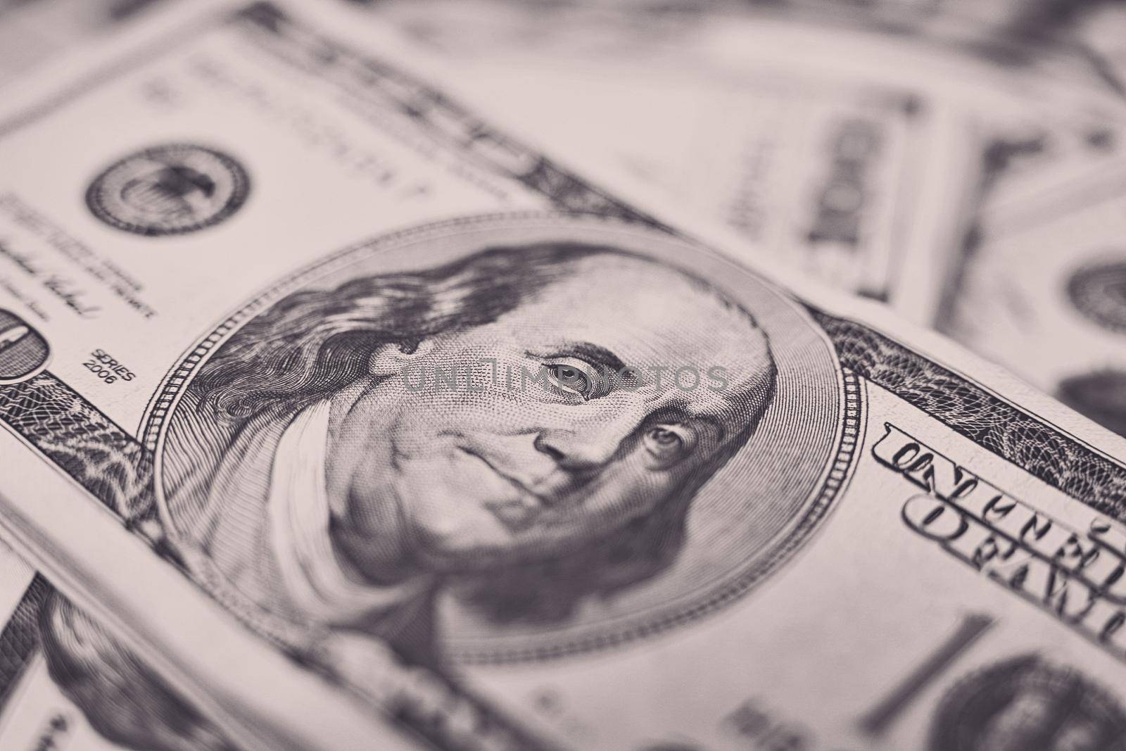 A stack of money. Heap of one hundred dollar bills on money background. Fake money. Shallow depth of field. Selective focus.