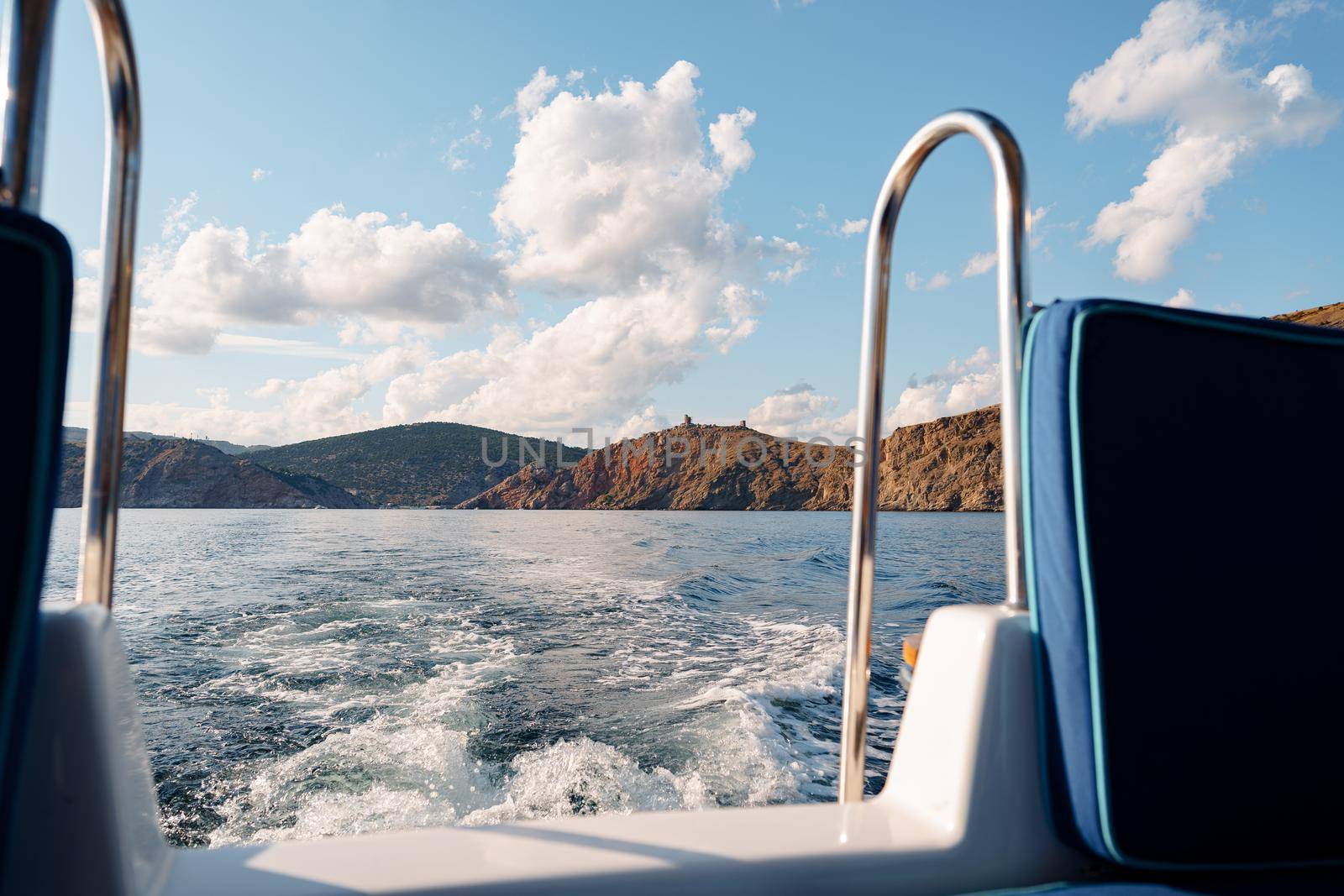 Motor yacht cruising in the open sea, view from the stern
