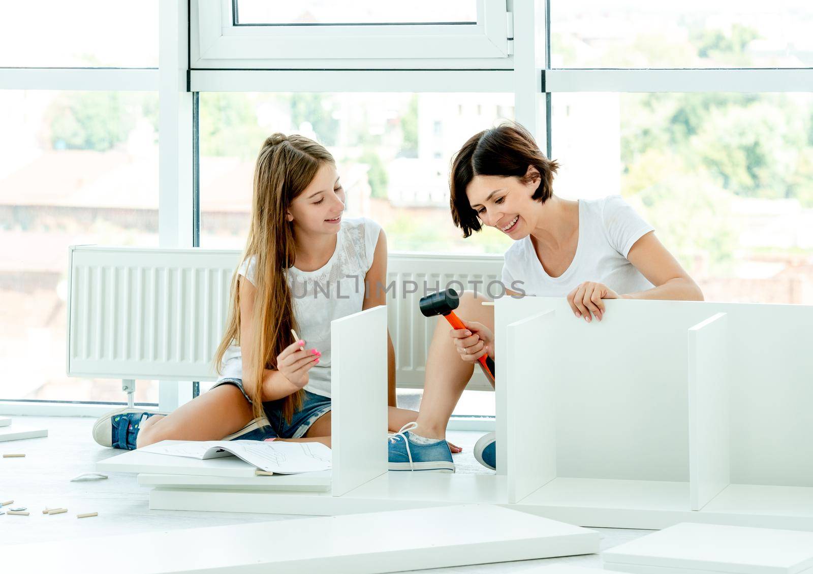 Cute family assembling brand new bookshelf by tan4ikk1