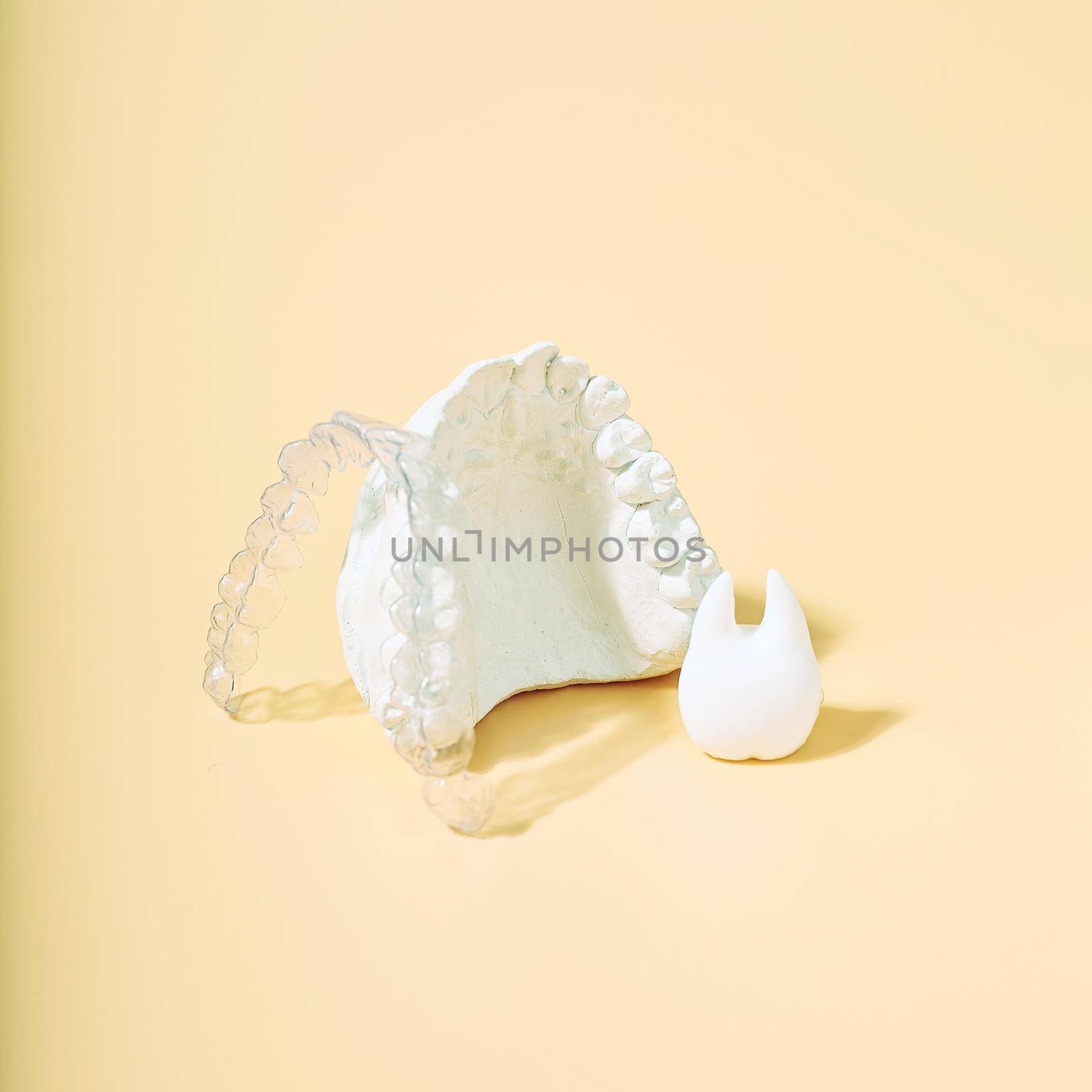 Orthodontic dental theme on  yellow background.Transparent invisible dental aligners or braces aplicable for an orthodontic dental treatment by Maximusnd