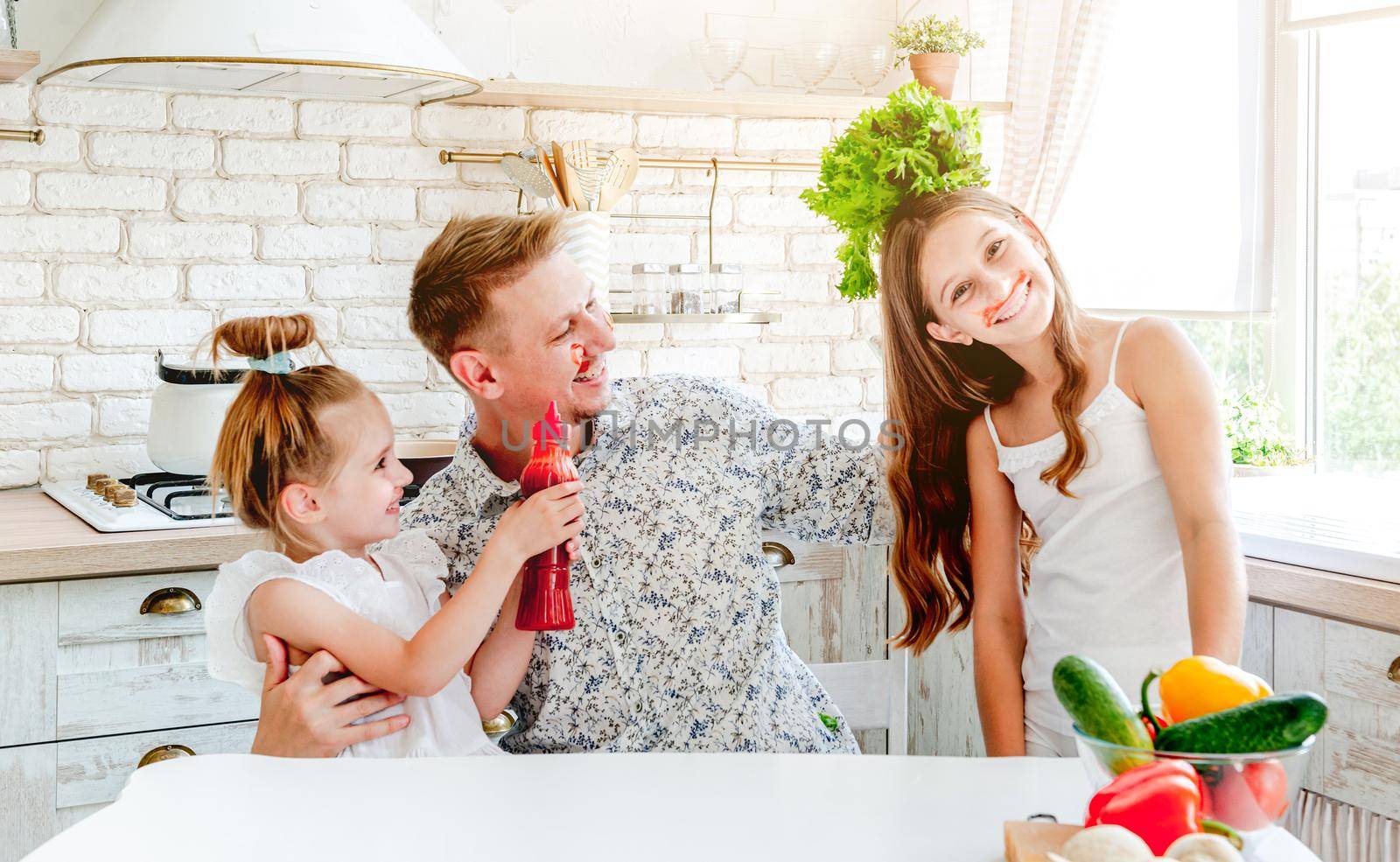 dad with two little daughters preparing pizza in the kitchen