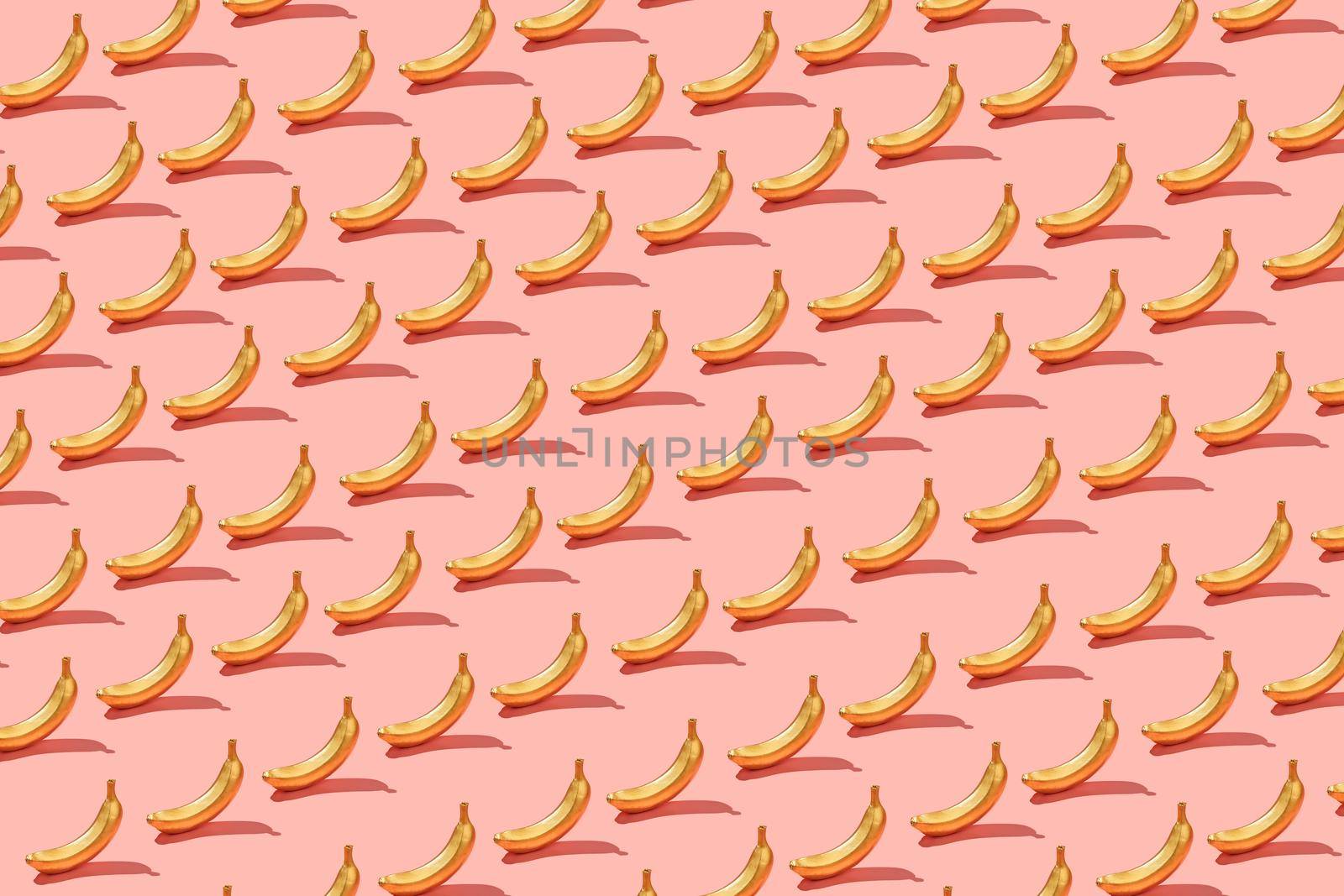 Trendy sunlight Summer pattern  yellow banana slice on bright light pink background. Minimal summer concept.