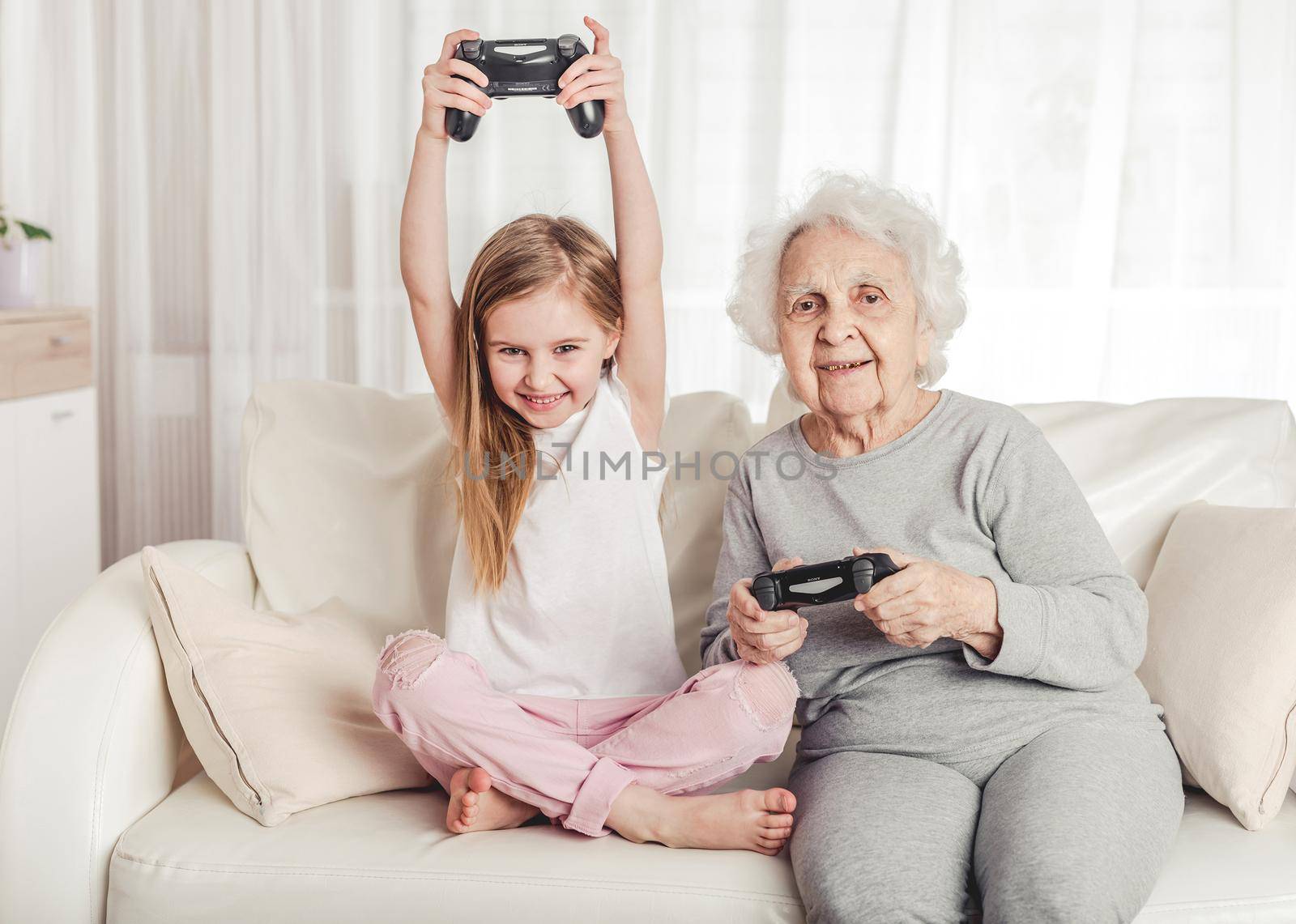 Grandmother with granddaughter playing games by tan4ikk1