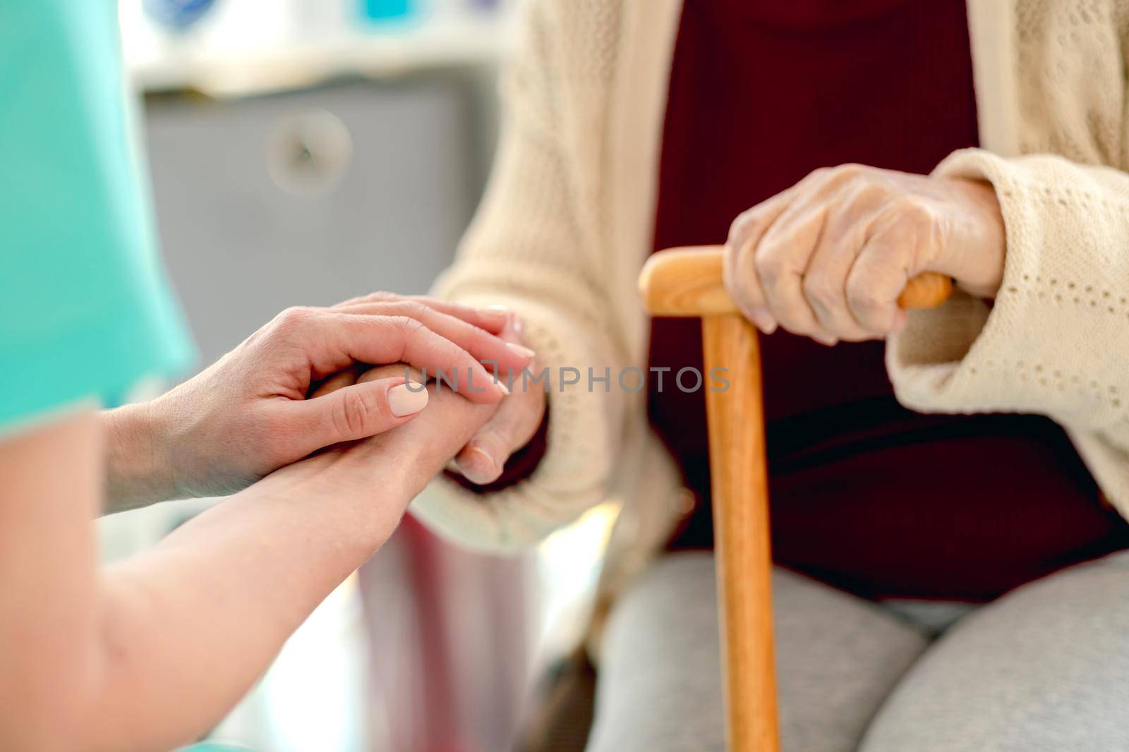 Close up view of senior woman hand in caregiver hands