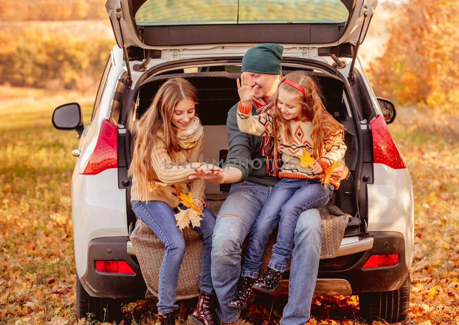 Smiling father with daughters in autumn surroundings