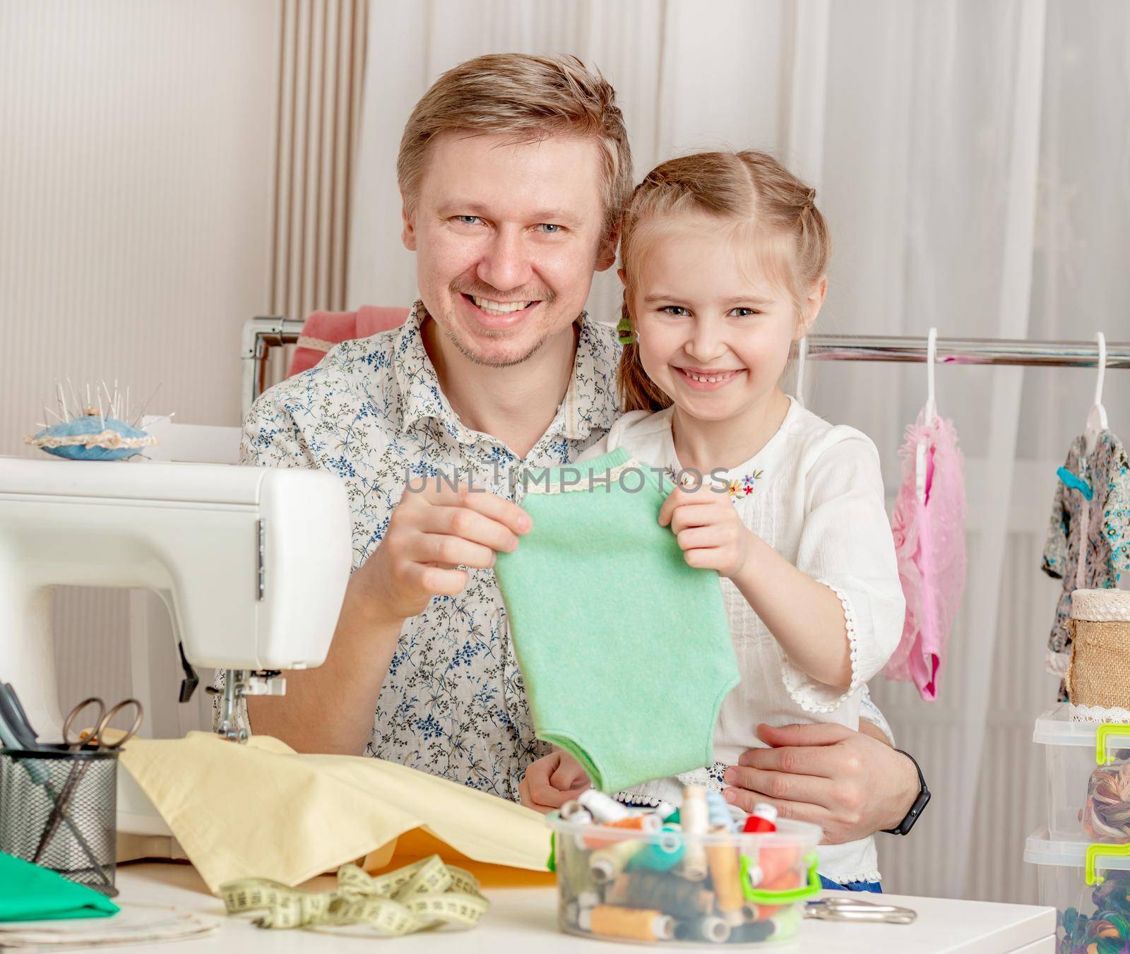 cute little girl and her dad in a sewing workshop