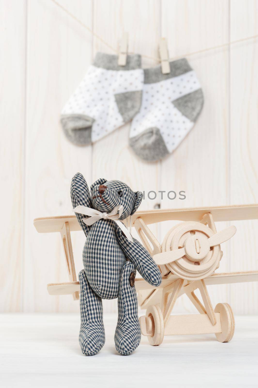 Cute teddy bear on wooden background with wooden baby toys