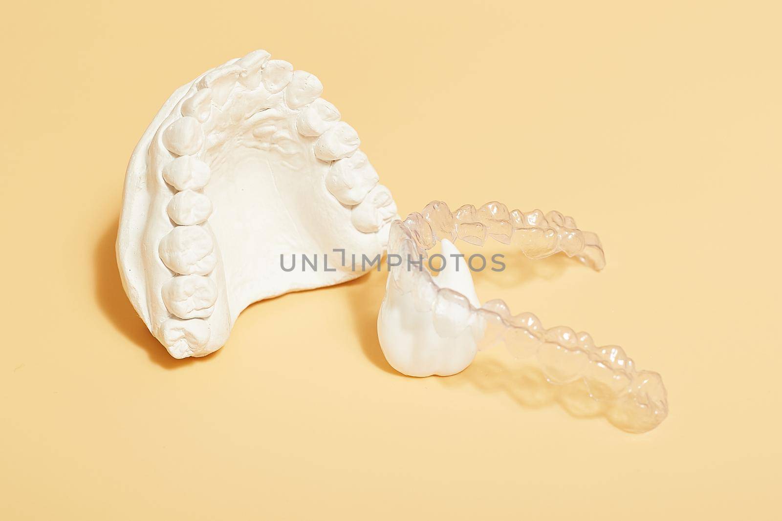 Orthodontic dental theme on  yellow background.Transparent invisible dental aligners or braces aplicable for an orthodontic dental treatment