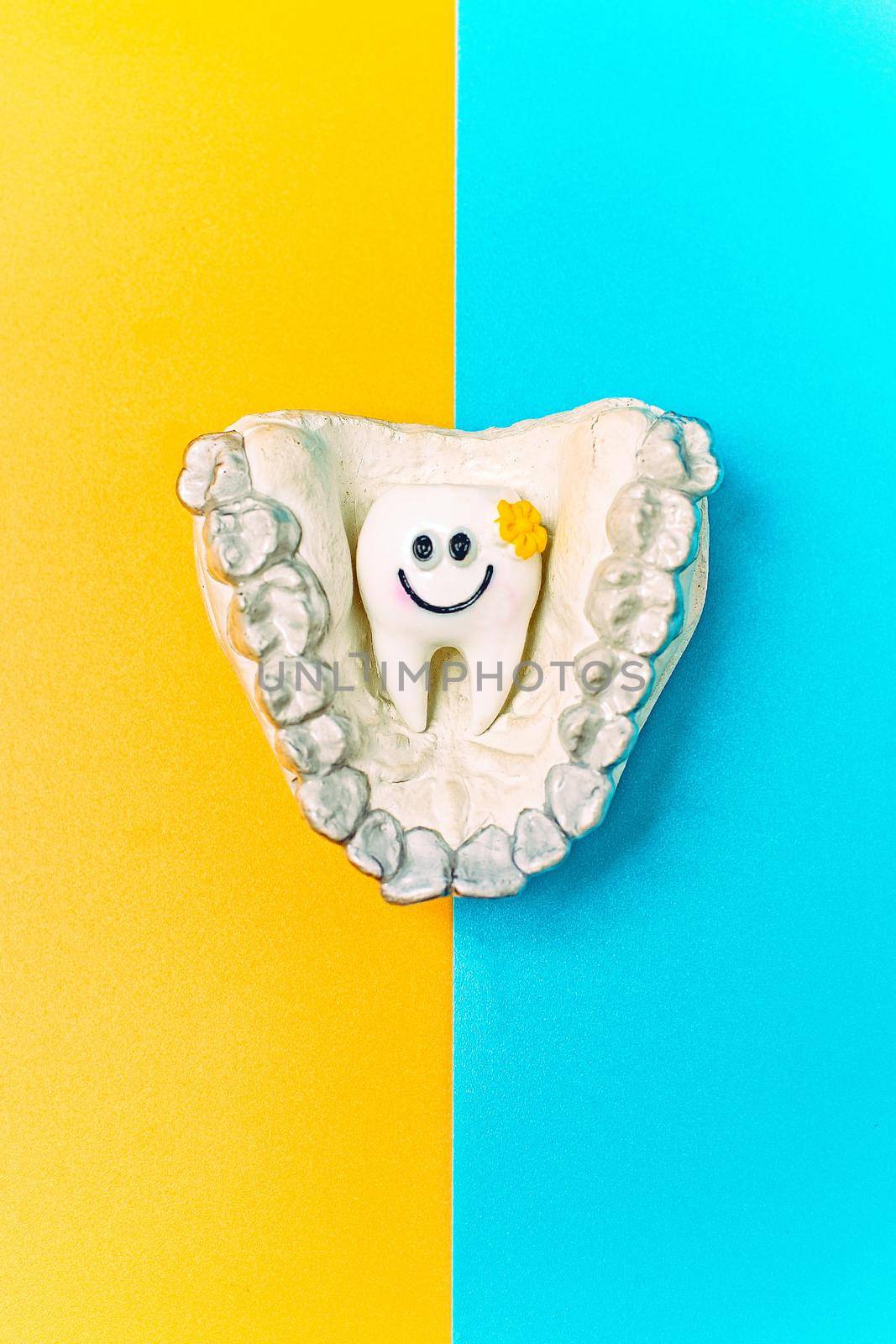 Orthodontic dental theme on blue and yellow background.Transparent invisible dental aligners or braces aplicable for an orthodontic dental treatment by Maximusnd