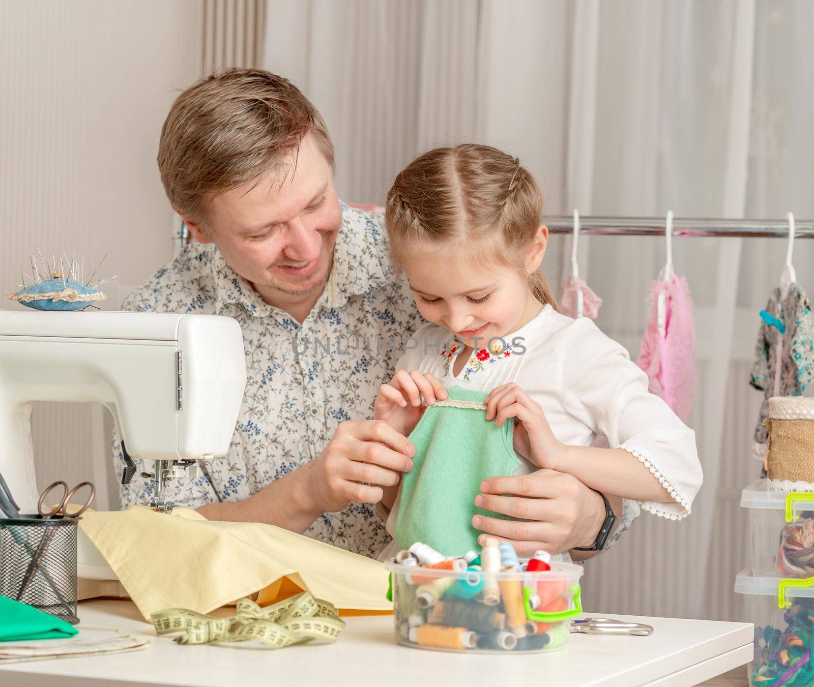 cute little girl and her dad in a sewing workshop