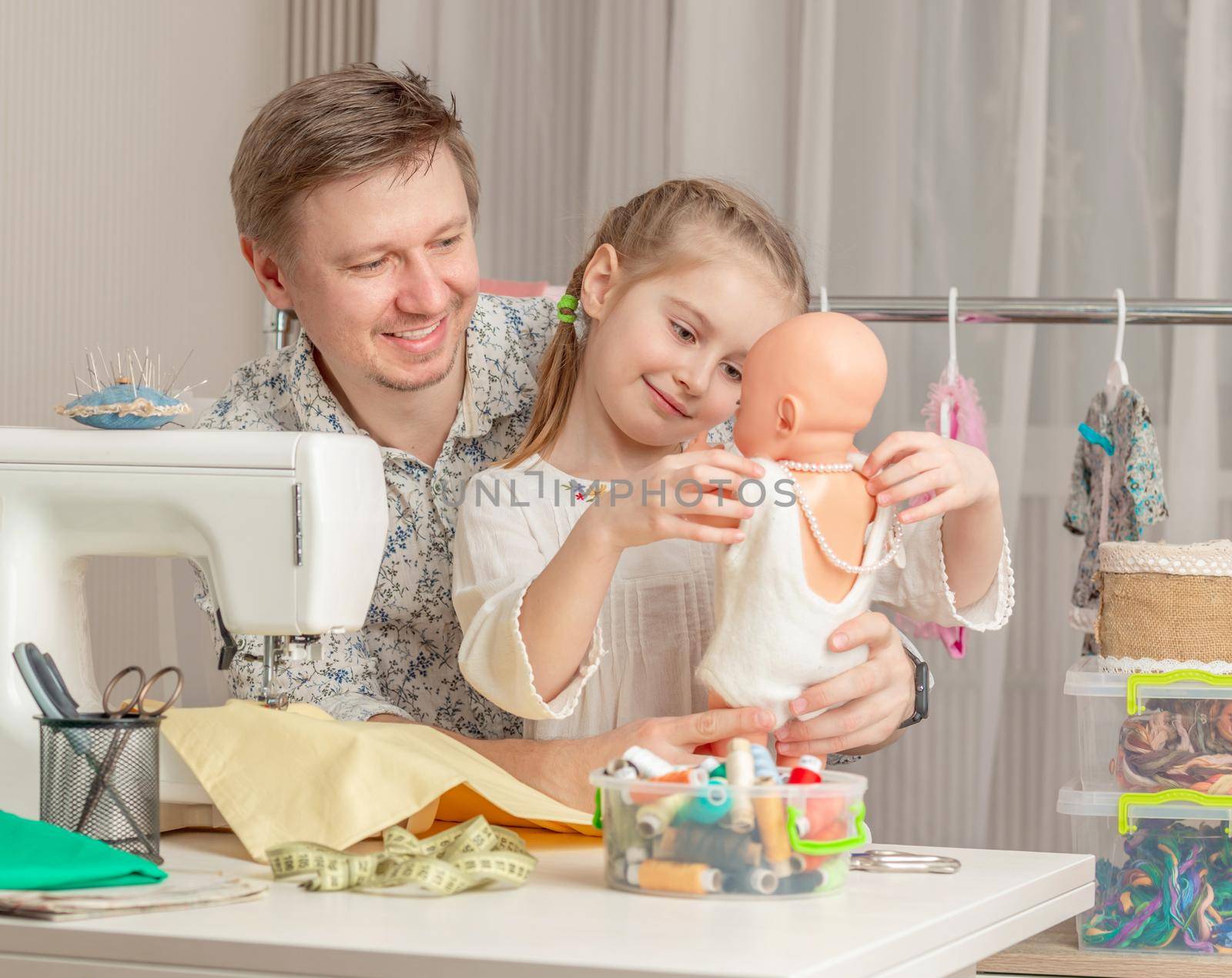 cute little girl and her dad in a sewing workshop