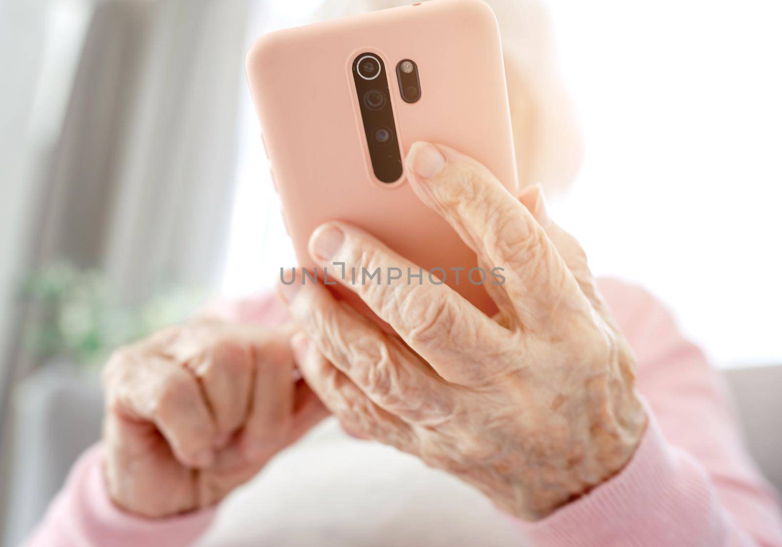 Senior woman hands with smartphone closeup. Elderly female person with modern cell phone