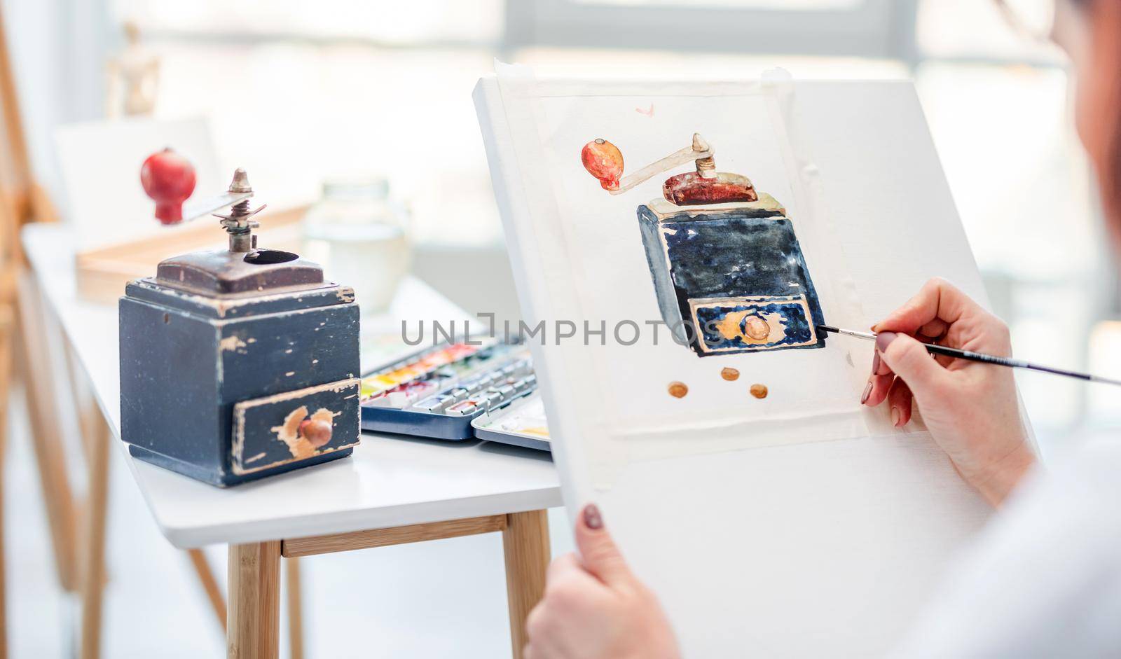 Woman holding white canvas and drawing vintage music box from natute with watercolor