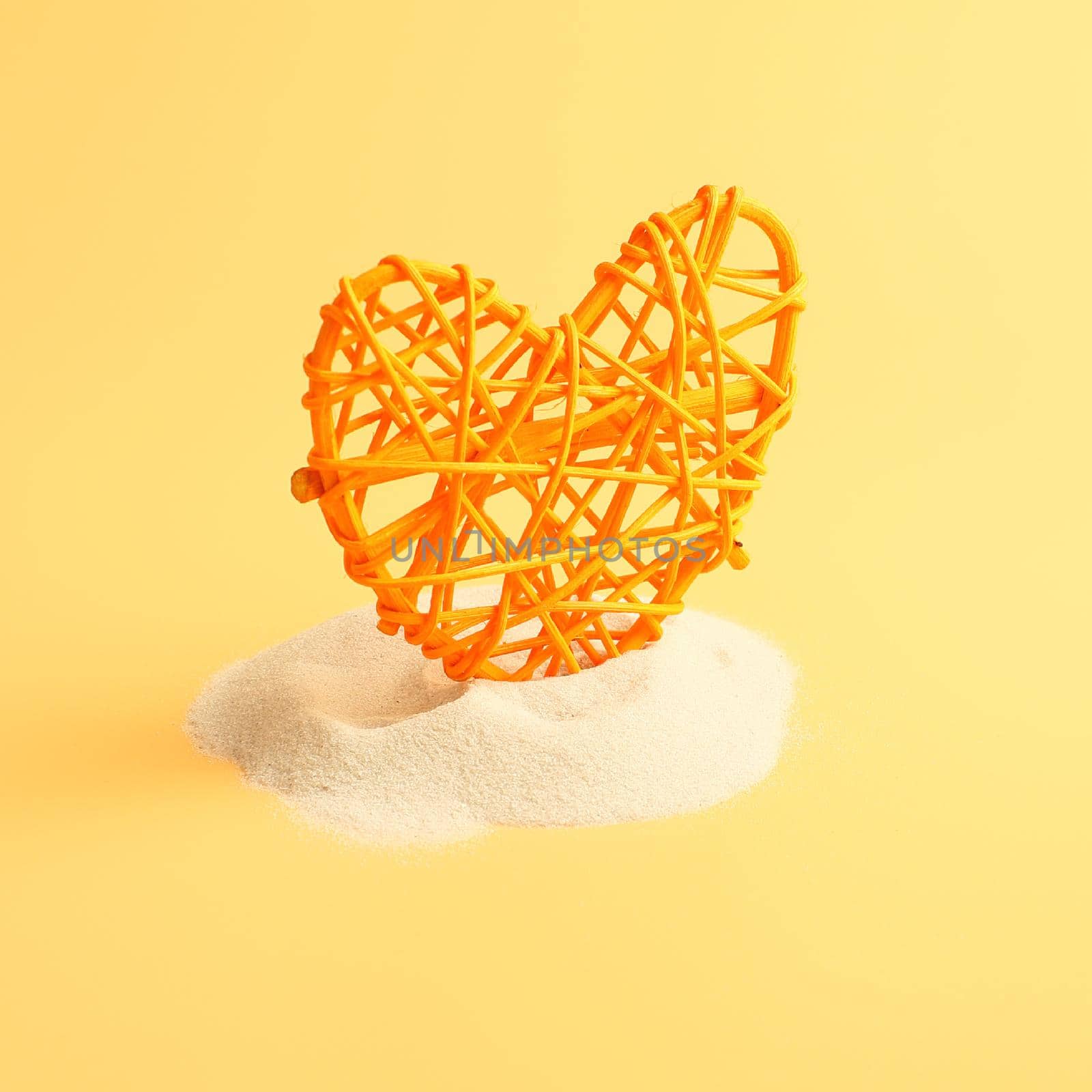 Heart in sand on yellow background, concept with shadow by Maximusnd