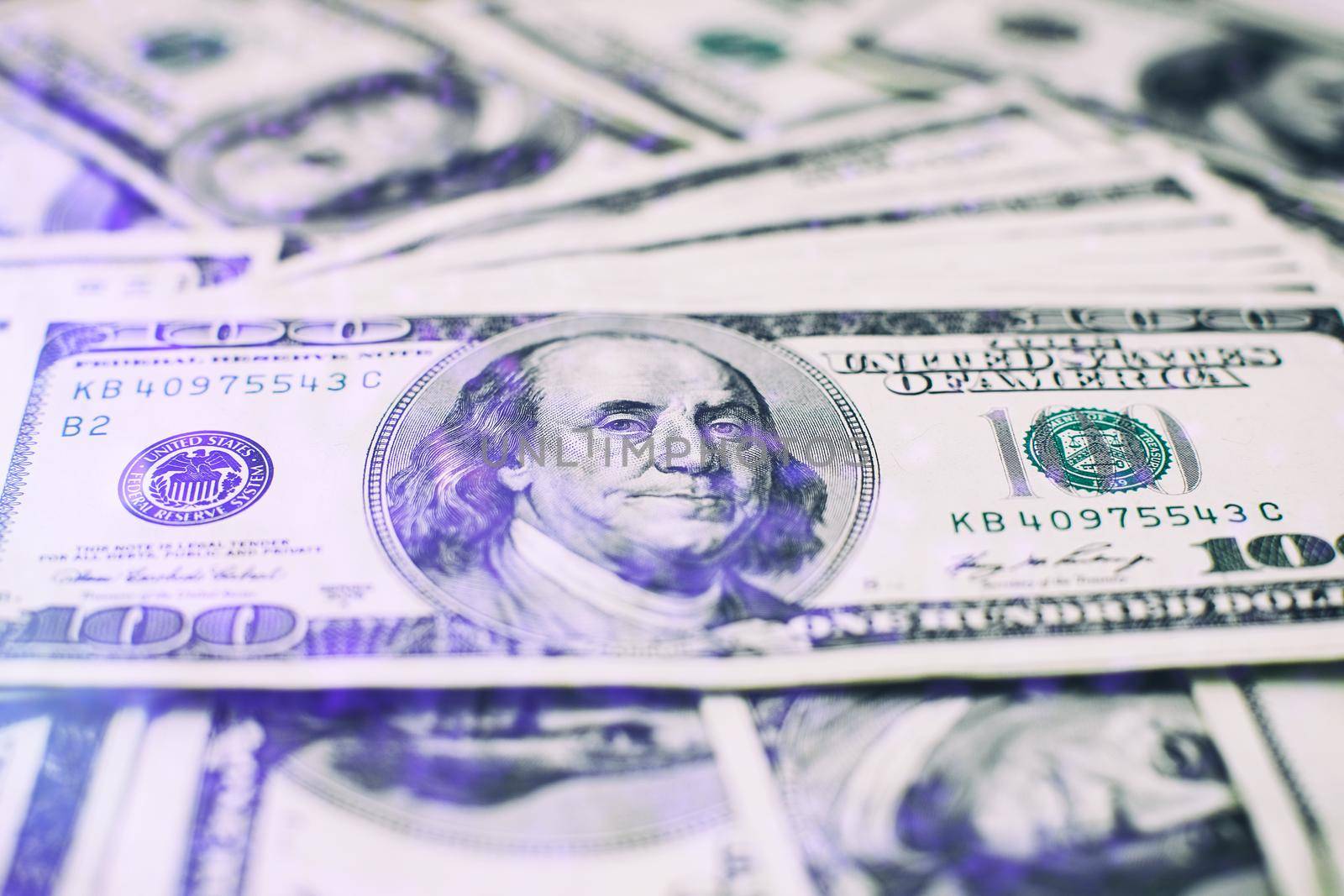 A stack of money. Heap of one hundred dollar bills on money background. Fake money. Shallow depth of field. Selective focus.