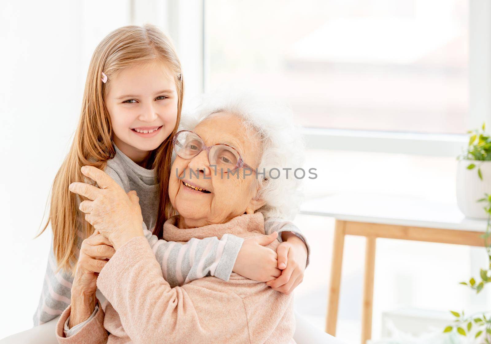 Lovely granny with granddaughter in light room