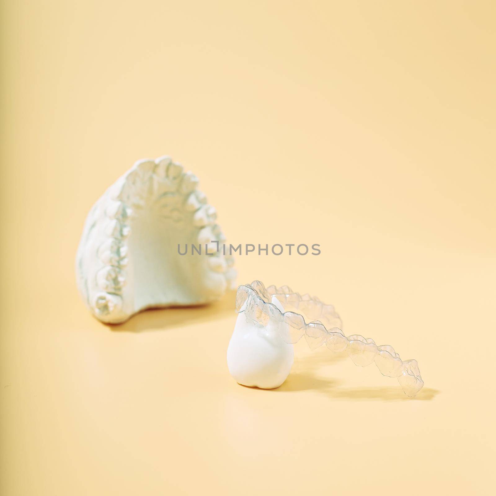 Orthodontic dental theme on  yellow background.Transparent invisible dental aligners or braces aplicable for an orthodontic dental treatment