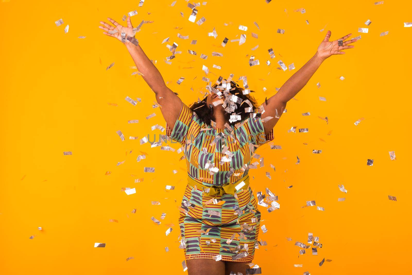 Celebrating happiness, young woman dancing with big smile throwing confetti