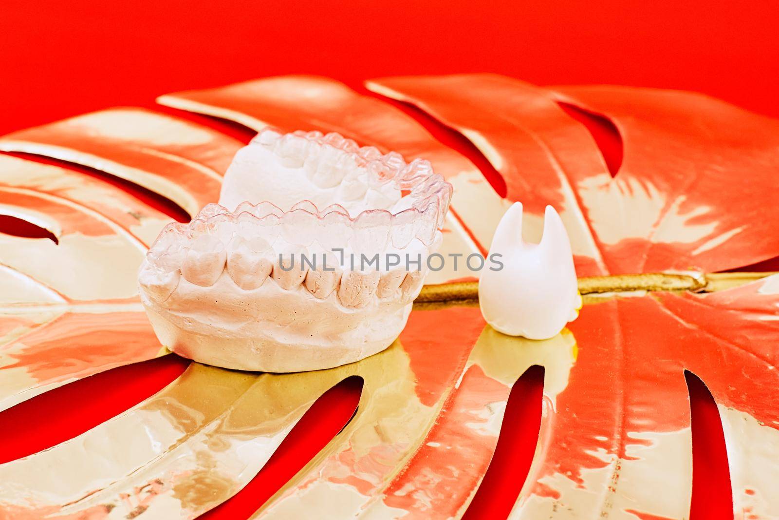 Heart of gold on a red background in invisible dental aligners or braces aplicable for an orthodontic dental treatment