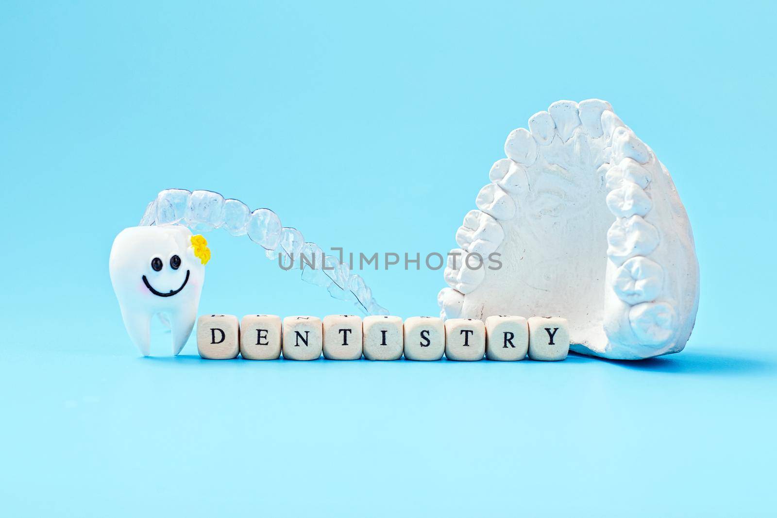 Dentist lettering for your advertisement on a blue background with invisible dental aligners or braces aplicable for an orthodontic dental treatment by Maximusnd