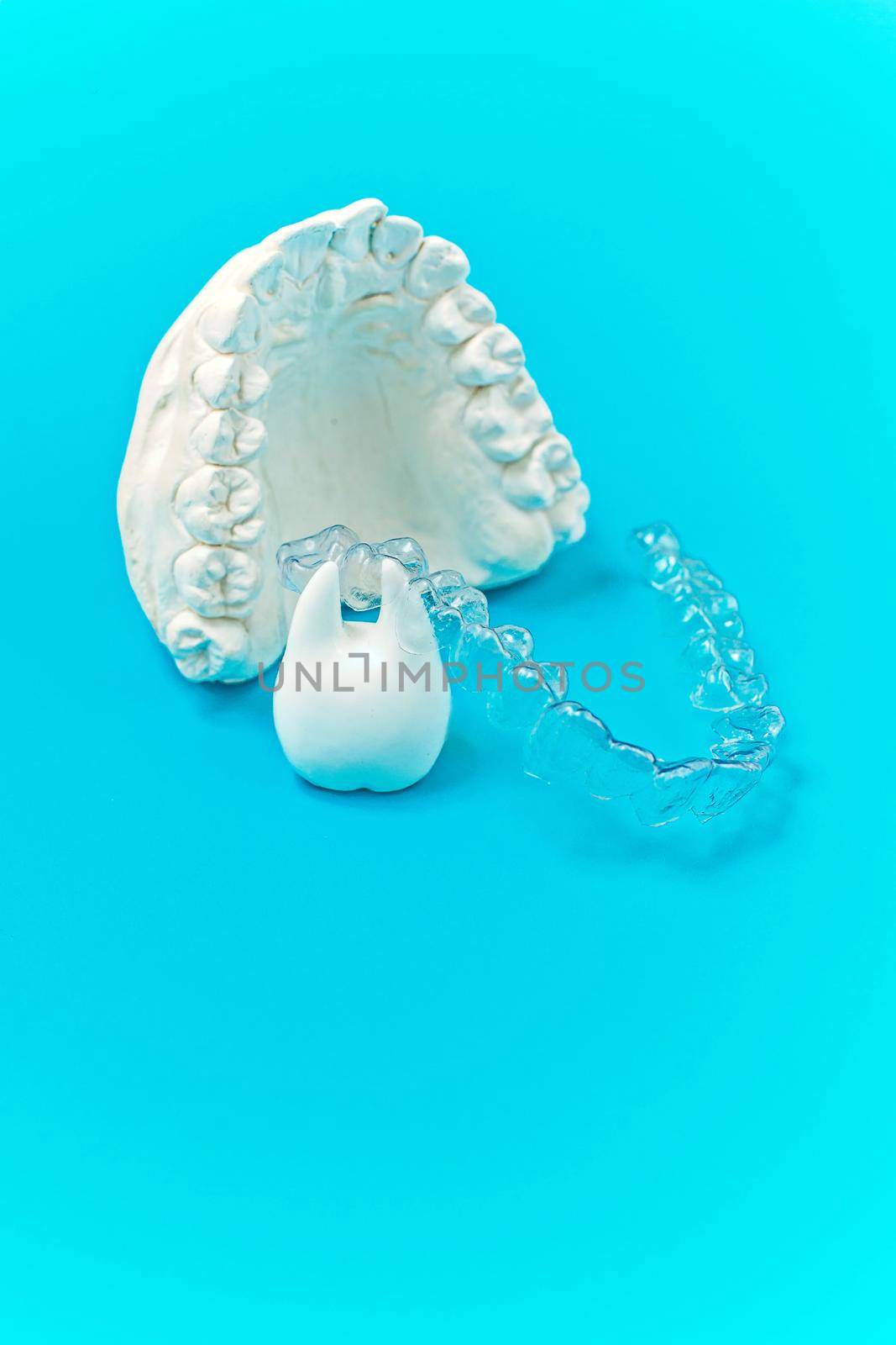 Orthodontic dental theme on blue background. Transparent invisible dental aligners or braces aplicable for an orthodontic dental treatment by Maximusnd