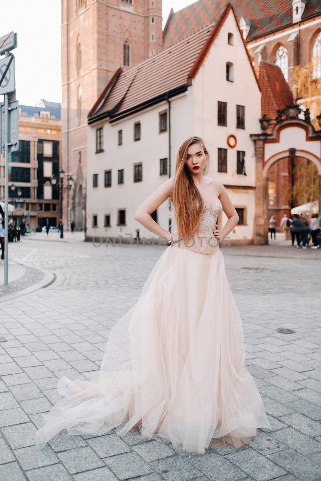 A bride in a wedding dress with long hair in the old town of Wroclaw. Wedding photo shoot in the center of an ancient city in Poland.Wroclaw, Poland by Lobachad