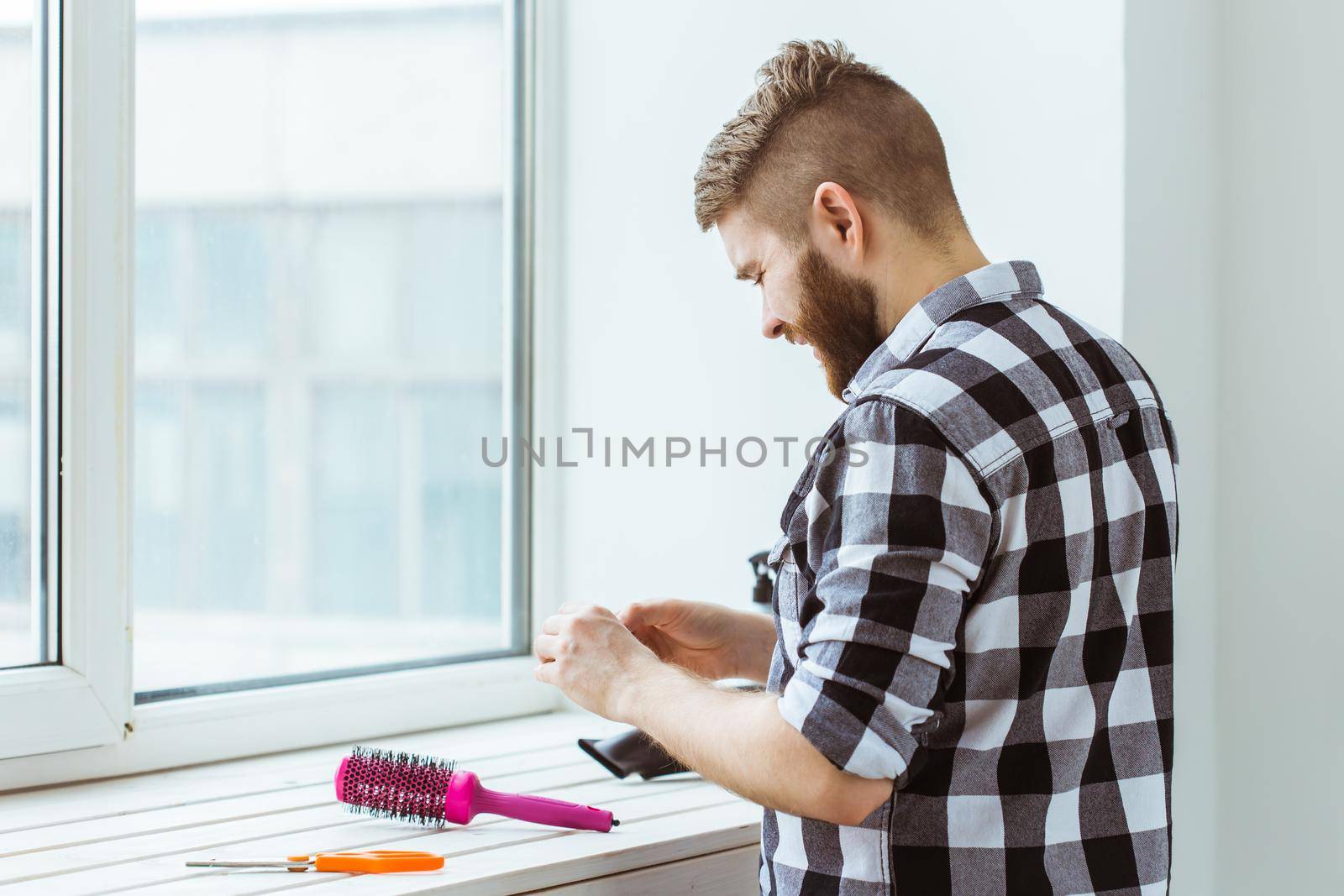 Fix and repair concept - Man working with a roll of adhesive aluminum foil tape in his hands. by Satura86