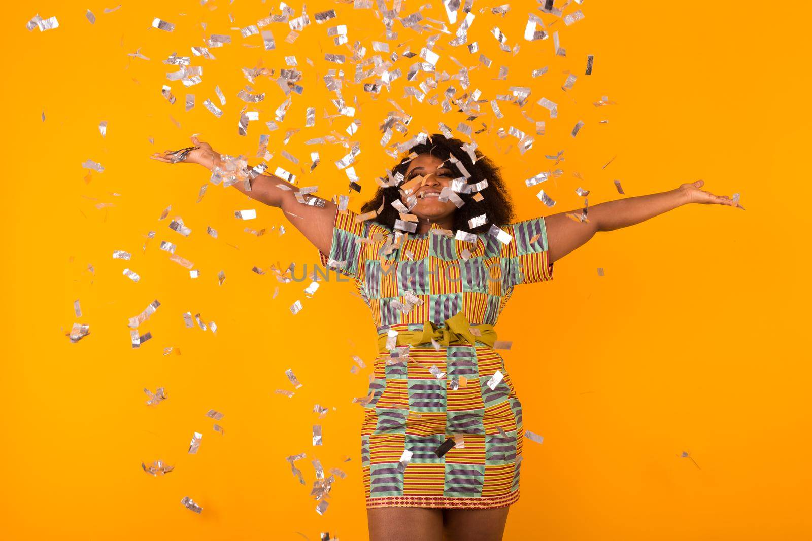 Celebrating happiness, young woman dancing with big smile throwing confetti