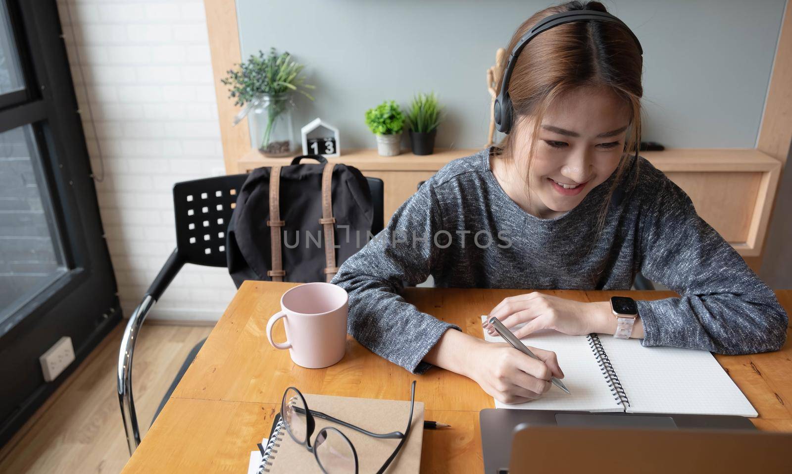 Cropped shot smiling asian woman freelancer wearing headset, communicating with client via video computer call. Millennial pleasant professional female tutor giving online language class by wichayada