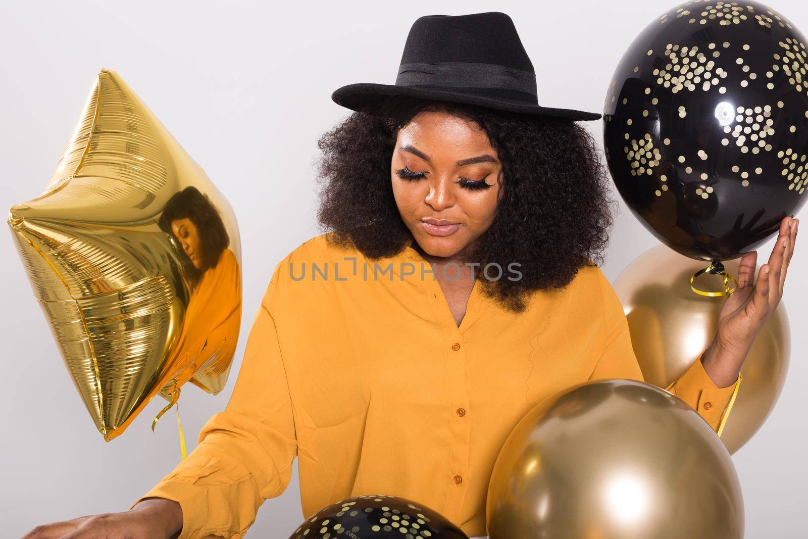 Holidays, party and fun concept - Portrait of smiling young African-American young woman looking stylish on white background holding balloons. by Satura86