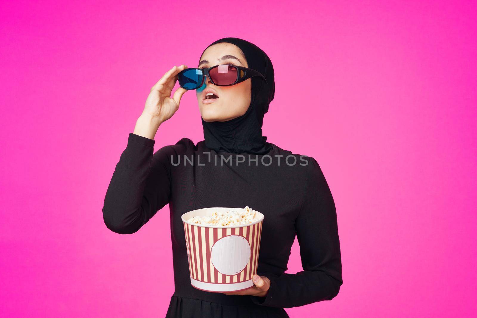 Muslim woman in 3D glasses popcorn entertainment movies isolated background. High quality photo