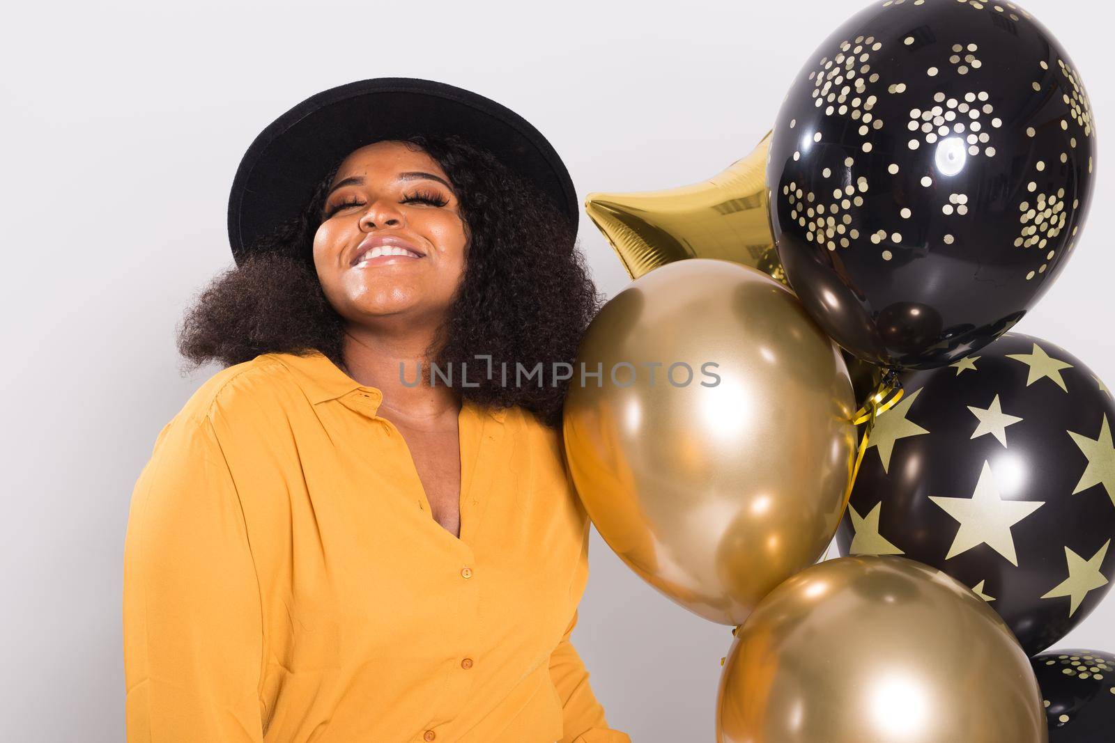 Holidays, birthday party and fun concept - Portrait of smiling young African-American young woman looking stylish on white background holding balloons. by Satura86