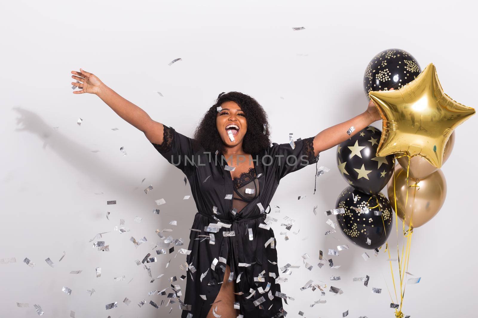 Celebrating happiness, young woman dancing with big smile throwing confetti